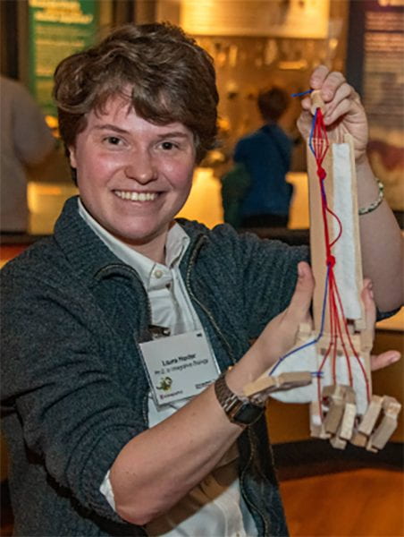 Laura at the 2024 Research Speaks event demonstrating her hand model